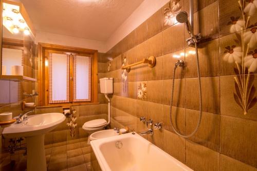uma casa de banho com uma banheira, um WC e um lavatório. em Apartment Paradise em Livigno