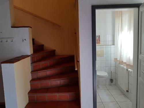 ein Badezimmer mit einer Treppe, einem WC und einem Badezimmer in der Unterkunft Große Wohnung / Haushälfte in Peetzig am See in Angermünde