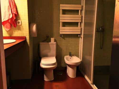 a small bathroom with a toilet and a sink at Albergue Azabache in Santiago de Compostela