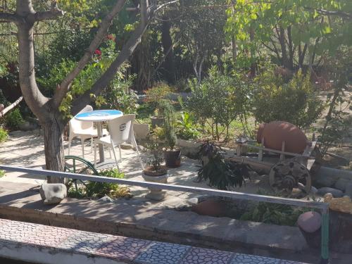 a garden with a table and chairs and a tree at Amiran's Lake in Tbilisi City