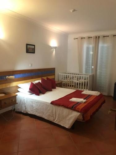 a bedroom with a large bed with red pillows at Charming Monte da Eira- one bedroom in Tavira