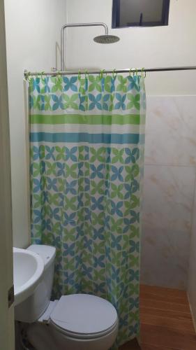 エルニドにあるHotel Ashoka (Authentic Indian Cuisine)のトイレとシャワーカーテン付きのバスルーム