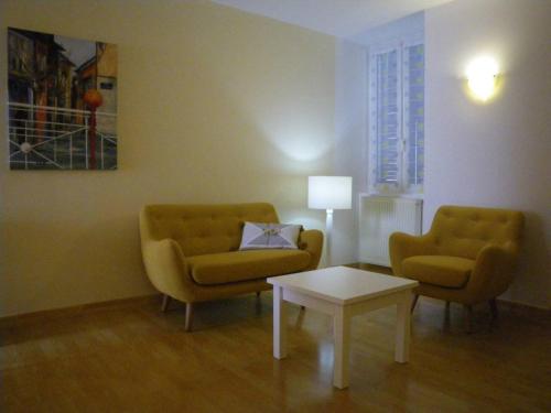 sala de estar con 2 sillas y mesa de centro en La Galerie Privée, en Pontcharra