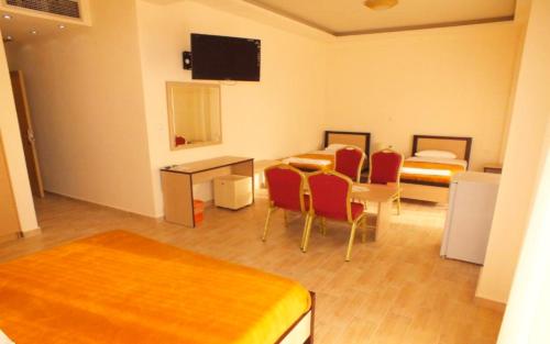 a room with two beds and a table and chairs at Hotel Victoria in Kilkís