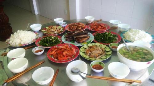 a table with plates of food and bowls of food at Nhà Nghỉ Mỹ Châu Lý Sơn in Ly Son