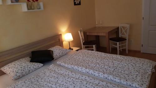 a bedroom with a bed and a table with a table at Apartman Lotos in Mikulov