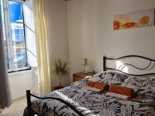ein Schlafzimmer mit einem Bett und einem Fenster in der Unterkunft Villa Atlantica Apartments in Angra do Heroísmo
