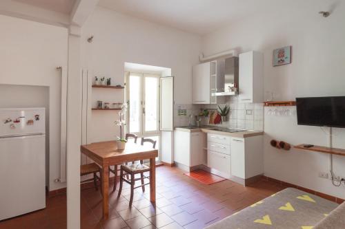 a kitchen with white cabinets and a table in it at Appartamento 121 in Prato
