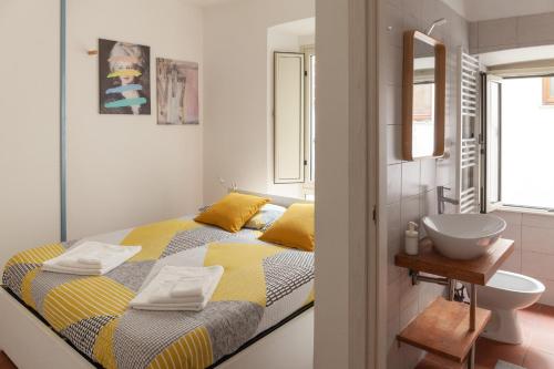 um pequeno quarto com uma cama e um lavatório em Appartamento 121 em Prato