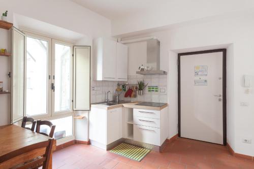 a kitchen with white cabinets and a table and a door at Appartamento 122 in Prato