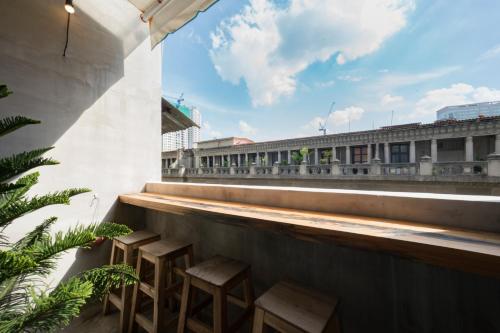 a row of stools on the roof of a building at CIRCADIAN Industrial Loft In Heritage Building in Ho Chi Minh City