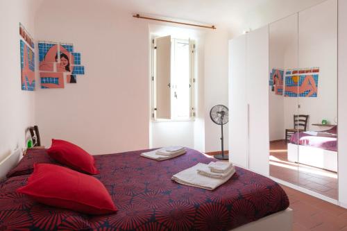 een slaapkamer met een bed met rode kussens bij Appartamento 123 in Prato