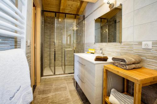 W łazience znajduje się umywalka i przeszklony prysznic. w obiekcie Chalet l’Aiglon w mieście La Rosière
