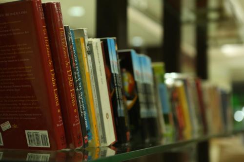 a row of books on a shelf in a library at Hotel Airlink Castle in Nedumbassery