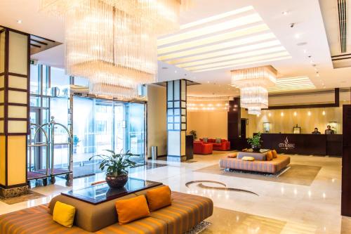 a lobby with couches and chairs in a building at City Seasons Hotel & Suites Muscat in Muscat