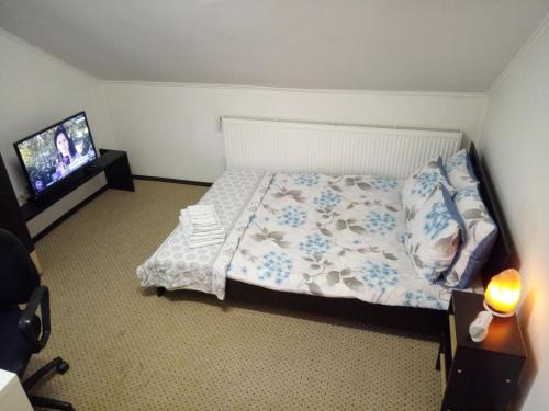 a bedroom with a bed and a flat screen tv at Elizabeth's Rooms in Gherla