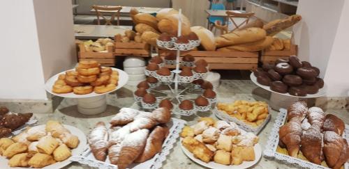 a bunch of different types of bread and pastries on plates at Gara Suites Golf & Spa in Playa de las Americas