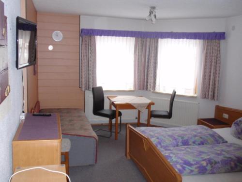 ein Hotelzimmer mit einem Bett, einem Schreibtisch und einem Tisch in der Unterkunft Appartement Mair in Sankt Leonhard im Pitztal