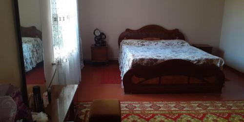 a bedroom with a bed in a room with a rug at Guest House OTILIA in Gyumri