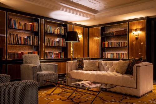 a living room filled with furniture and a bookcase at Maison Albar Hotels Le Monumental Palace in Porto