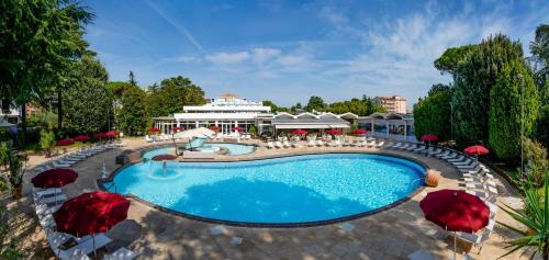 a pool at a resort with chairs and umbrellas at Hotel Mioni Royal San in Montegrotto Terme