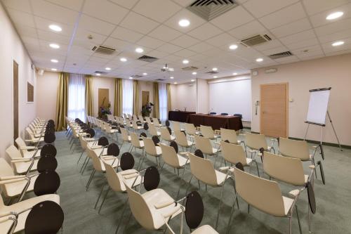 a room with rows of chairs and a podium at Hotel Mioni Royal San in Montegrotto Terme
