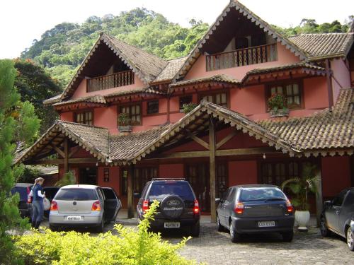 ein Gebäude mit davor geparkten Autos in der Unterkunft Pousada Alemã Schwambach (+ café da manhã) in Domingos Martins