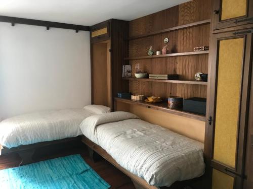 2 camas en una habitación con estanterías de madera en Manu happy house Cir 0104, en Breuil-Cervinia