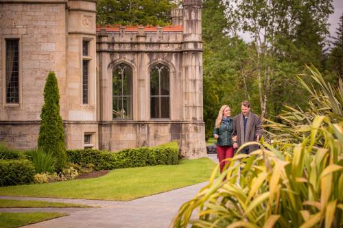 un hombre y una mujer caminando delante de un edificio en Lough Eske Castle en Donegal