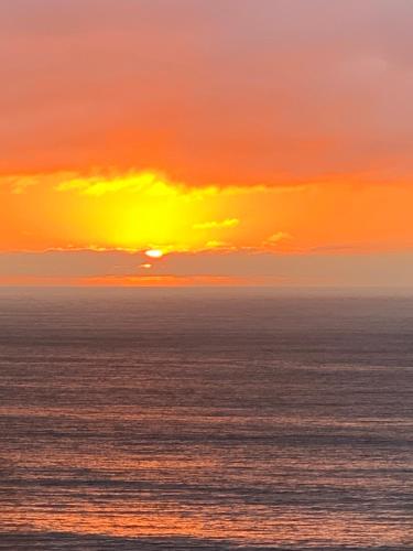 an orange and yellow sunset over the ocean at Condominio San Alfonso Del Mar - Vista Inmejorable in Algarrobo