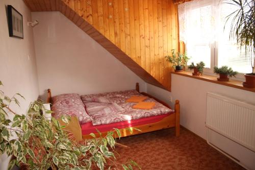 a small bed in a room with a staircase at Chalupa Boskovice in Boskovice