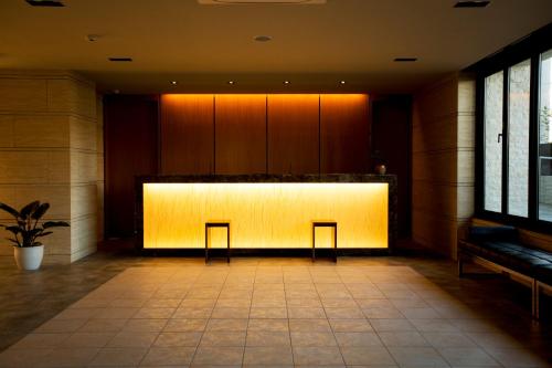 a lobby with two chairs and a lit up wall at Sakura Terrace in Kyoto