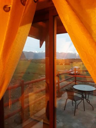 a view from a room with a table and a window at CABAÑA PARCELA VISTA HERMOSA in Puerto Aisén