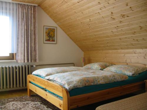 two beds in a bedroom with a wooden ceiling at Ferienwohnung Peter Engelhardt in Schmiedefeld am Rennsteig
