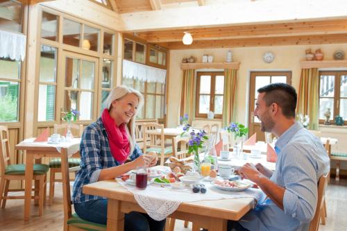a man and woman sitting at a table in a restaurant at Weingut Schauer in Kitzeck im Sausal