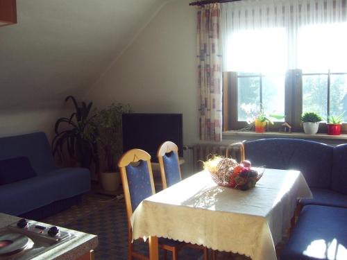 uma sala de estar com uma mesa e cadeiras e um sofá em Ferienwohnung Peter Engelhardt em Schmiedefeld am Rennsteig