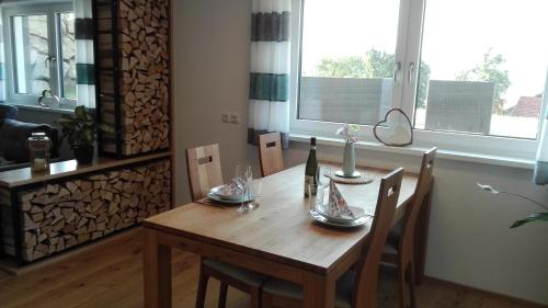 a dining room table with chairs and a bottle of wine at Ferienwohnung Alpenpanorama in Hopferau