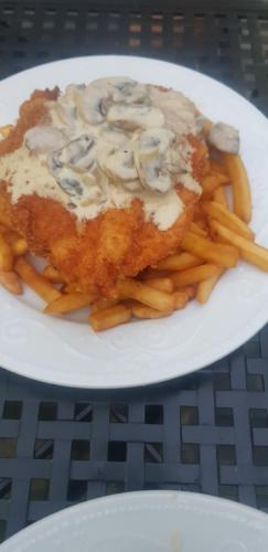 a plate of food with french fries on a table at Mai Danube in Eşelniţa