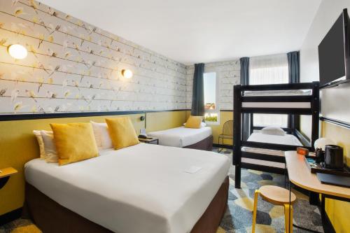 Pokój hotelowy z 2 łóżkami i biurkiem w obiekcie Best Western Hôtel Grand Parc Marne La Vallée w mieście Chanteloup-en-Brie