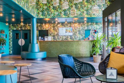 a lobby with chairs and a bar with plants at Best Western Hôtel Grand Parc Marne La Vallée in Chanteloup-en-Brie