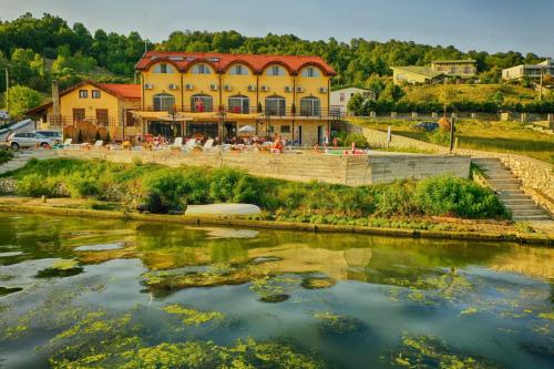 a large yellow building next to a river at Mai Danube in Eşelniţa