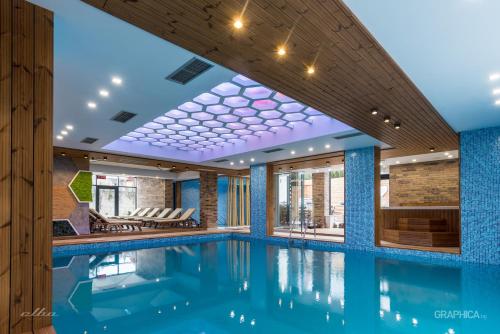 a swimming pool in a hotel with blue walls and a ceiling at 103 Degrees Hotel & Spa in Sapareva Banya