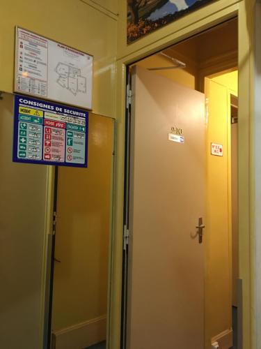a sign on a wall in a hallway with two doors at A la Pinte du Nord in Paris