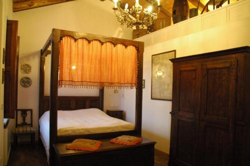 La Corte Di Gerardo في Tonco: غرفة نوم فيها سرير مظلة وثريا
