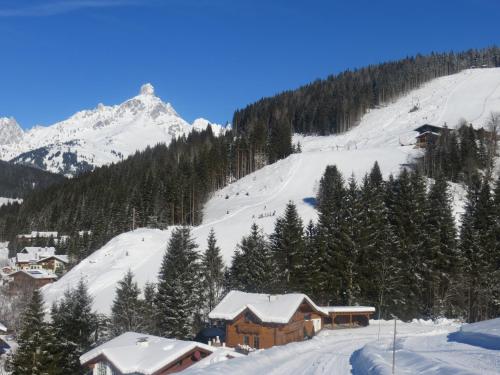 a ski lodge in the snow with a mountain at Appartement Hartl in Filzmoos
