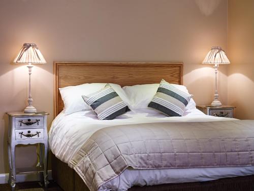 a bedroom with a bed with two night stands with lamps at 1885 the Venue - Pub, Restaurant, Rooms & Function House in Halifax