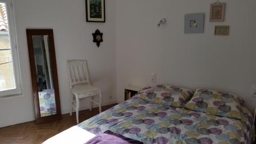 ein Schlafzimmer mit einem Bett, einem Stuhl und einem Fenster in der Unterkunft Appartement centre historique Beziers in Béziers