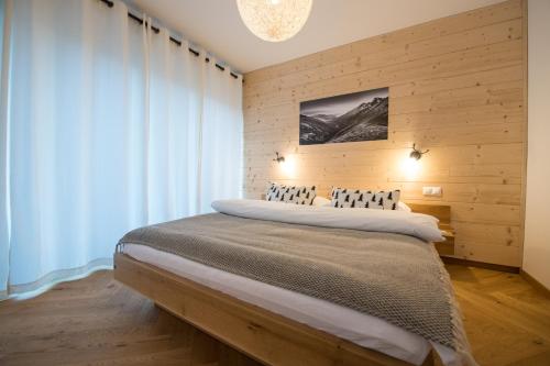 ein Schlafzimmer mit einem großen Bett und einer Holzwand in der Unterkunft Lomnica Garden Apartment in Tatranská Lomnica