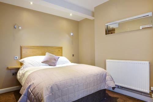 a bedroom with a large bed and a mirror at 1885 the Venue - Pub, Restaurant, Rooms & Function House in Halifax