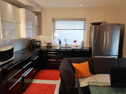 a kitchen with an orange pillow on a couch at Villa Baneheia in Kristiansand